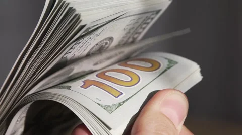 Hand leafing through a stack of dollar bills. Slow motion Stock Footage 64231493