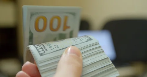 Hand leafing through a stack of dollar bills. Slow motion. Stock Footage 126418872