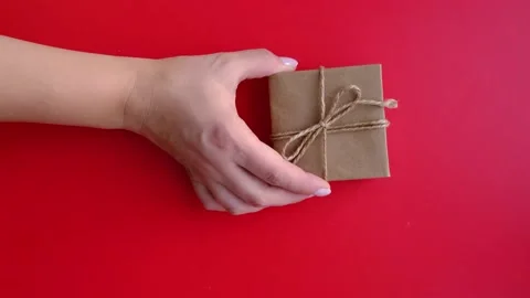 The hand leaves the gift on a red background. A layout with space for your text. Stock Footage 165794844