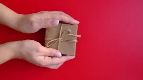 The hand leaves the gift on a red background. A layout with space for your text. Video stock 166095383