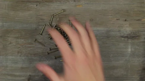 A hand leaves a mound of nails Stock Footage 24866022