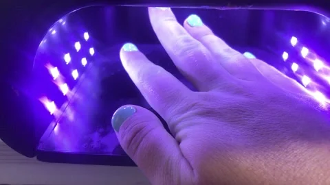 The hand is in the LED lamp for drying gel polish. Stock Footage 131664423