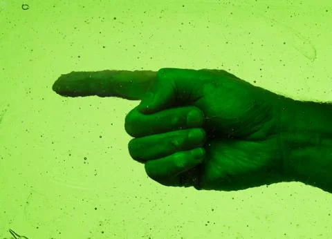 Hand with left pointed finger behind a pane of weathered vintage green glass Stock Photos