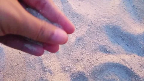 Hand Letting Sand Flow Through Fingers on the Beach Stock Footage 287935973