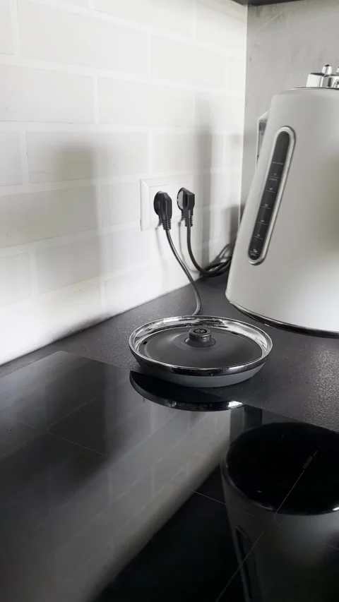 Hand Lifting a Boiled Electric Kettle from Its Power Base Stock Footage 340138211