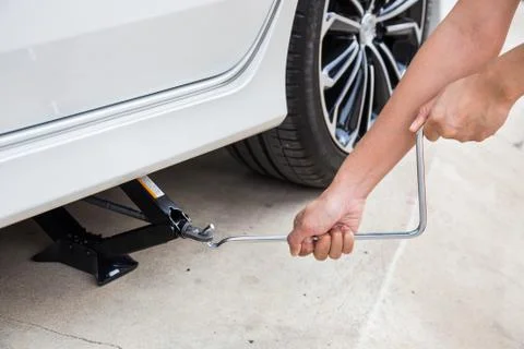 Hand lifting a car with spanner jack-screw Stock Photos