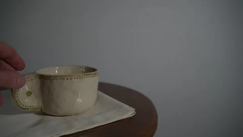 Hand lifting coffee cup on table Video stock 327350089