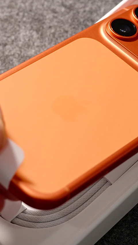 Hand Lifting Cosmic Orange iPhone 17 Pro from Box Using Tab with Triple Camera Stock Footage 318057350