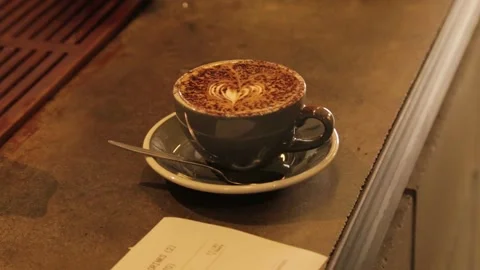 Hand Lifting Decorated Coffee Cup From Cafe Counter in Sydney, Australia Stock Footage 345692165