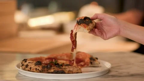 Hand Lifting Fresh Pizza Slice with Melting Cheese in Italian Restaurant Stock Footage 340244268