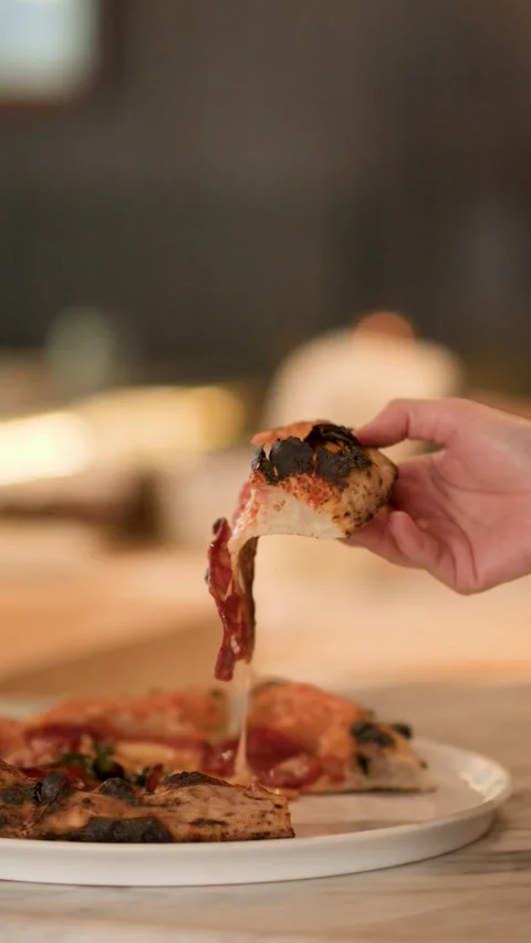 Hand Lifting Fresh Pizza Slice with Melting Cheese Pull Stock Footage 340303592