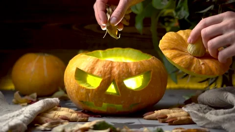 Hand is lifting a lid of the pumpkin and putting ingredients to make the potion Stock Footage 194406641
