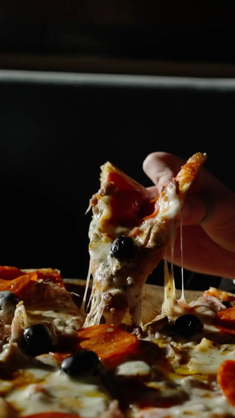 Hand lifting pepperoni pizza slice, stretching mozzarella cheese strings in slow Stock Footage 301372390