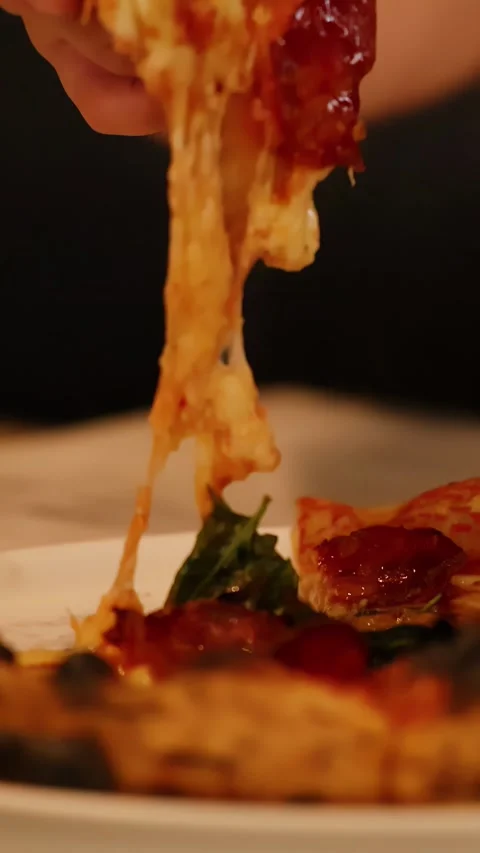 Hand Lifting Pepperoni Pizza Slice with Long Melted Cheese Pull Stock Footage 339119245