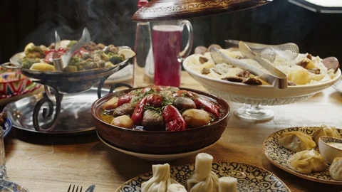 Hand lifting tagine lid at a table with various dishes Stock Footage 301529234