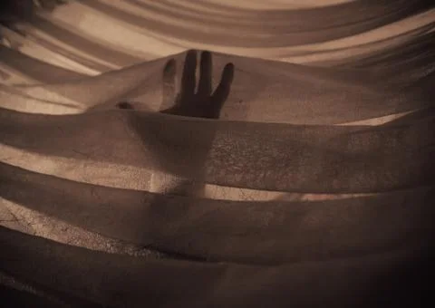 Hand in the Light touching fabric Stock Photos