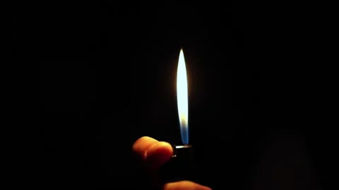 In hand a lighter with fire on a dark background Vídeo Stock 229724929