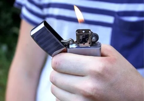 Hand, lighter, flame of fire Stock Photos