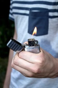 Hand, lighter, flame of fire Stock Photos
