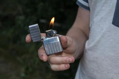 Hand, lighter, flame of fire Stock Photos