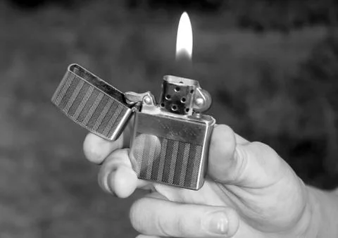 Hand, lighter, flame of fire Stock Photos