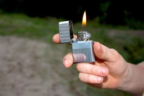 Hand, lighter, flame of fire Stock Photos