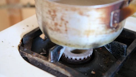 Hand lighting fire with match at gas stove with pot, flame going running out Vidéo 111405251