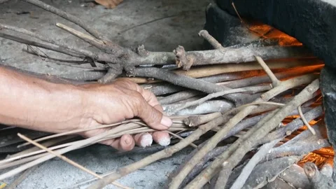 Hand lighting a fire using a traditional stove with firewood. Stock Footage 300858182