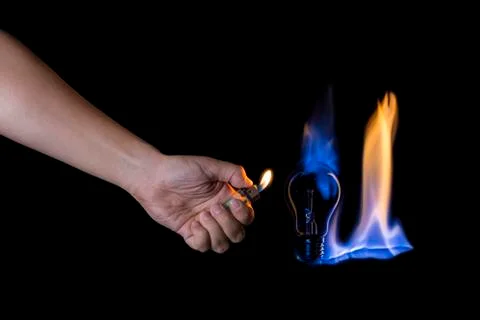 Hand lighting a lightbulb instead a candle Stock Photos