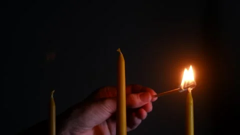 Hand lighting row of candles with match in the dark Video stock 312987148