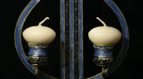 Hand lighting up two white candles in a candlestick Stock Footage 21325482