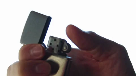 Hand lighting a Zippo lighter in front of a neutral white background. Stock Footage 175315218