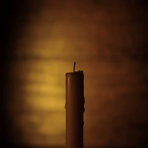 The Hand Lights a Candle on the Dark Brown Background Stockbeeldmateriaal 69377261