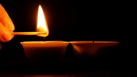 Hand lights a candle with a match in the dark. Stock Footage 122767684