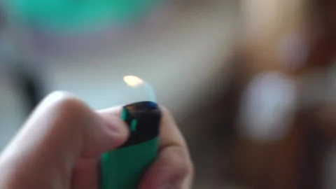 The hand lights a fire with a lighter and drives it through the air Stock Footage 139688499