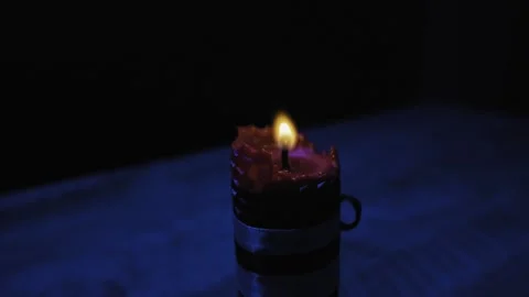A hand lights a red candle with a match in a dark, smoky room. Stock Footage 330296663