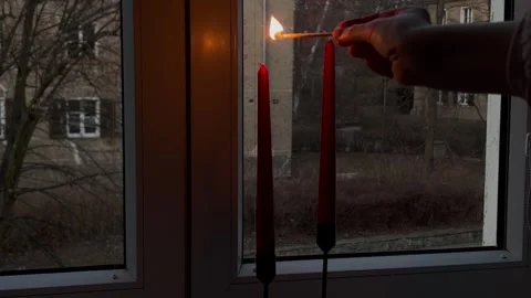 The hand lights two red candles on the windowsill Stock Footage 304611437