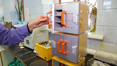 A hand in a lilac robe opens the door of the metal silver-yellow equipment Stock Footage 128603806