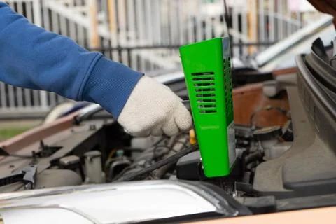 Hand with a load fork to check the car battery. Stock Photos