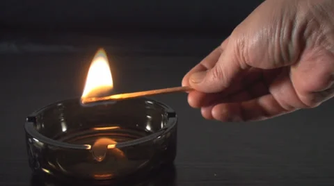 Hand With A Long Match Burning In The Ashtray Point Of View Video stock 34470459