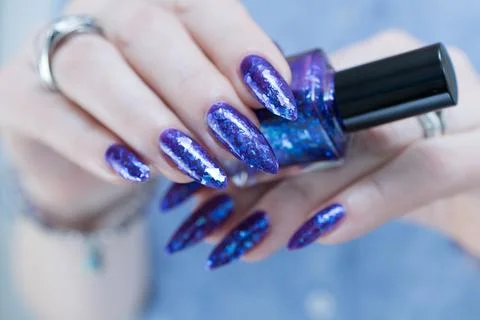 Hand with long nails and a blue and purple color nail polish Stock Photos