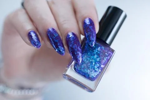 Hand with long nails and a blue and purple color nail polish Stock Photos