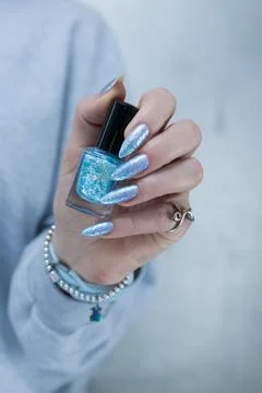 Hand with long nails and bright light blue and silver manicure Foto stock