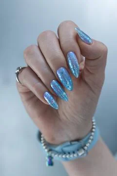 Hand with long nails and bright light blue and silver manicure Stock-Fotos
