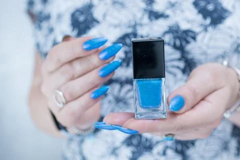 Hand with long nails and bright blue manicure 스톡 사진