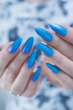 Hand with long nails and bright blue manicure 스톡 사진