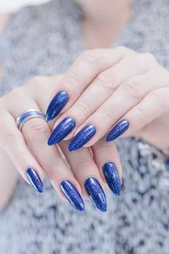 Hand with long nails and bright blue purple manicure Stock Photos