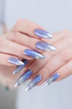 Hand with long nails and bright light blue and silver manicure Foto stock