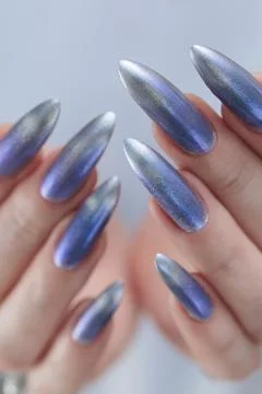 Hand with long nails and bright light blue and silver manicure Stock Photos