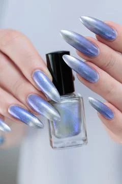 Hand with long nails and bright light blue and silver manicure 写真素材